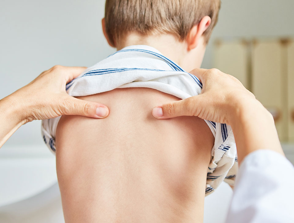 Ostéopathe examinant le dos d’un jeune enfant