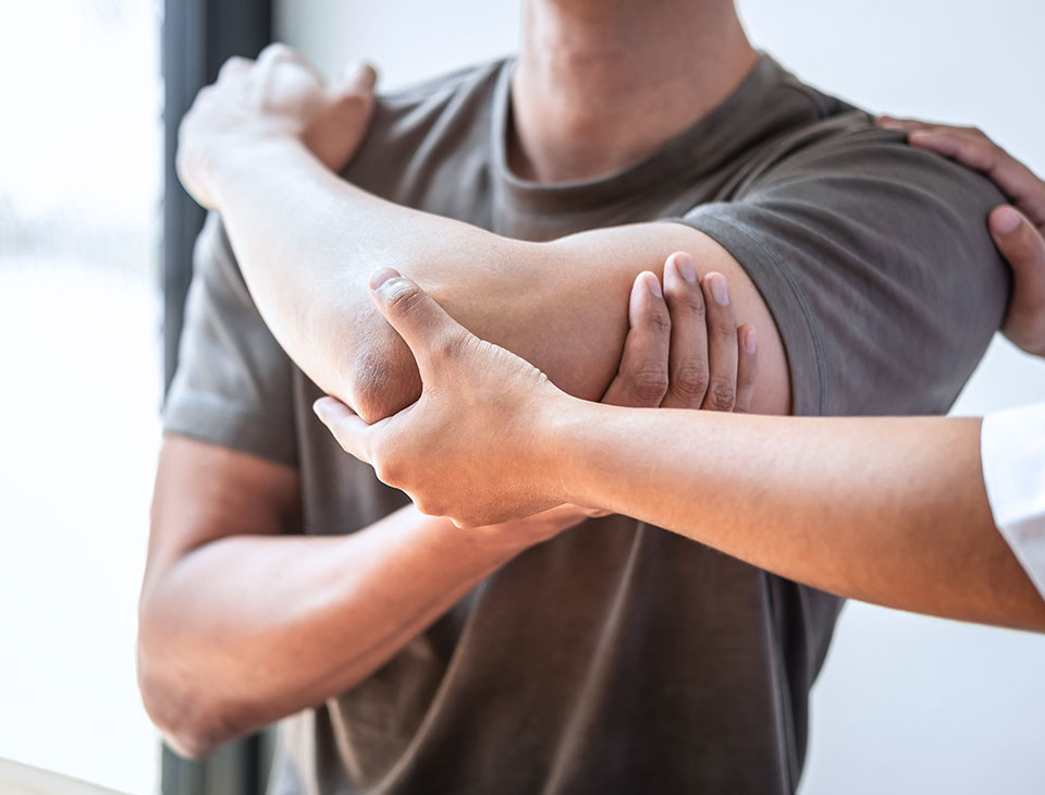 Mobilisation de l’épaule d’un adulte en séance d’ostéopathie